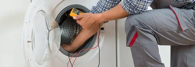 Dryer repair technician inspecting and repairing a clothes dryer in Syracuse, NY