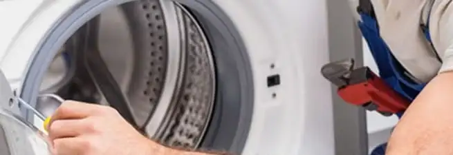 Appliance technician repairing a clothes dryer drum and internal parts in Syracuse, NY
