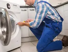 Washing machine repair technician servicing a front-load washer in Syracuse, NY
