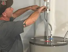 Water heater repair technician tightening supply line connections in Syracuse, NY